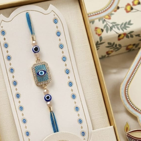 Neel Nazar Rakhi - Square evil eye Rakhi with turquoise enamel and blue tassel